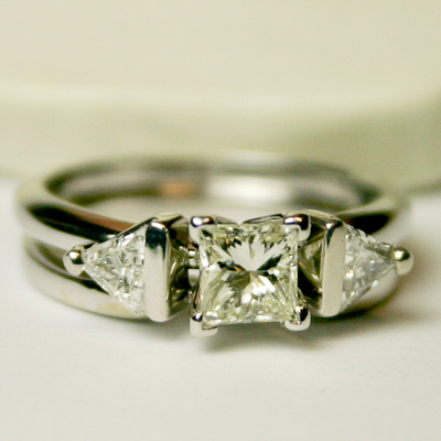 Princess cut center stone with two side stones set in platinum